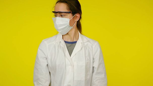 Молодий лікар в захисній медичній масці, окулярах і білій шубці
 - Фото, зображення