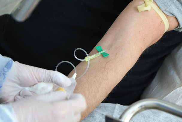 Infermiera prende un campione di sangue da un paziente per un esame del sangue a causa di un possibile caso di coronavirus covid-19
 - Foto, immagini