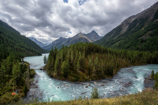 Stormy, mountain river in Altai, on the background of mountain peaks with dense vegetation along the banks - Foto, Imagem