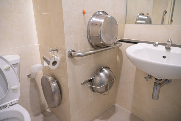 Toilettes à l'hôpital pour les patients et les personnes handicapées il ya des installations, placard, lavabo poignée en acier inoxydable pour les personnes handicapées sur le sol de tuiles et miroir
. - Photo, image