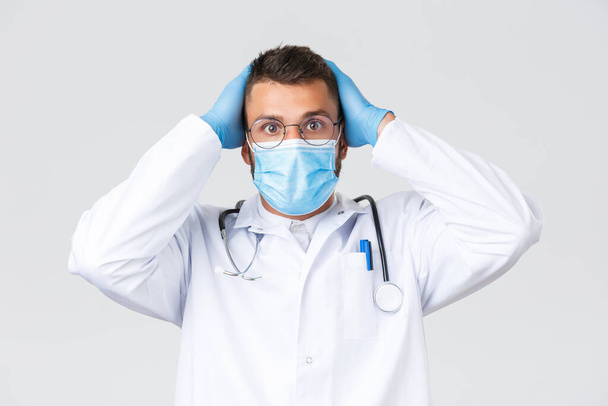白に隔離された蒸し眼鏡や医療用マスクを持つ医師の正面図 ロイヤリティフリー写真 画像素材