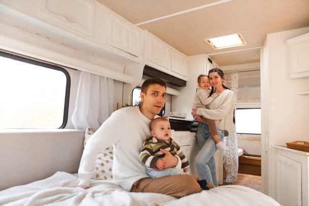 Portrait of the smiling happy family with kids in the house on wheels indoor - 写真・画像