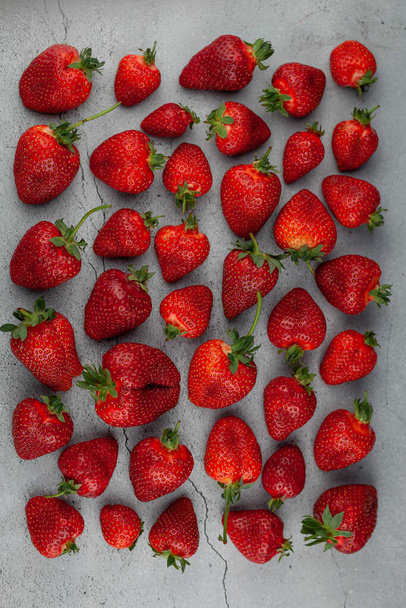 Strawberries on the table top view. Red berries pattern. Strawberry crop. Food still life in the spotlight. Red berry background. - Foto, Imagem