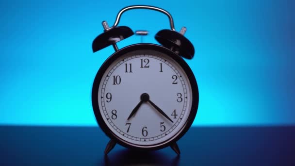 Black alarm clock on a blue background.  - Footage, Video