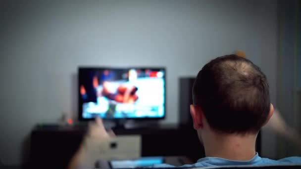 Egy férfi nézi a meccset a tévében, aggódik, integet a kezével, erős érzelmek, visszapillantás - Felvétel, videó
