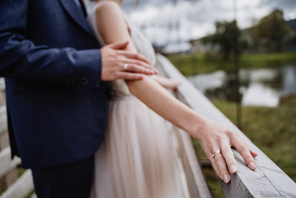 um homem e uma mulher seguram a mão um do outro, anel de casamento no dedo, recém-casados juntos, momento do casamento, relacionamento
 - Foto, Imagem