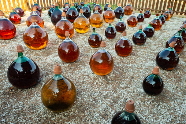 Produzione di liquore al moscato dolce naturale vino bianco all'aperto in grandi bottiglie rotonde di vetro antico demijohn a Frontignan, Francia
 - Foto, immagini