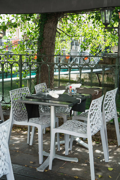 Vacío acogedor café de la calle francesa o brasserie situado en el pequeño río con mesas servidas listas para los visitantes, vacaciones de verano
 - Foto, imagen