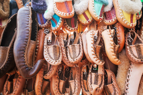 A hagyományos szerb retro kézműves bőrcipők közelsége a helyi vásár standján eladó - Fotó, kép