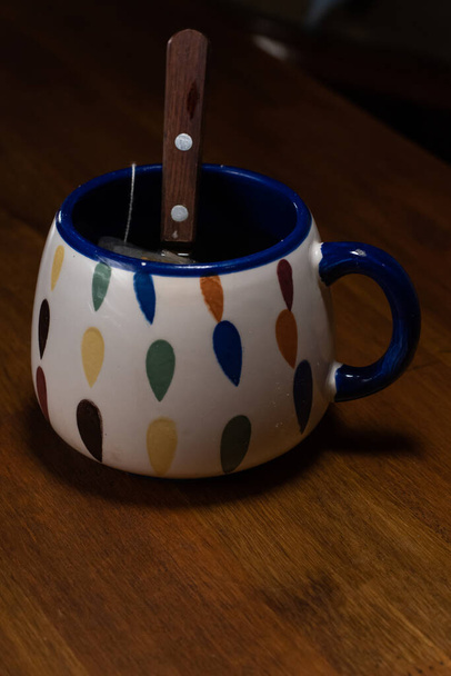 Una taza de té sobre una mesa de madera con una cuchara en ella
 - Foto, Imagen