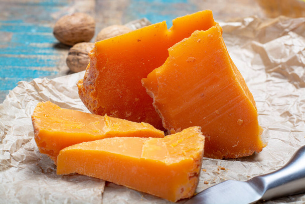Pieces of native French aged cheese Mimolette, produced in Lille with greyish curst made by special cheese mites close up - Zdjęcie, obraz