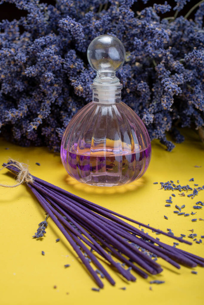 Aromathérapie naturelle saine et parfum d'intérieur, bâtonnets d'encens lavande violette et diffuseur sur fond jaune avec fleurs de lavande séchées gros plan
 - Photo, image