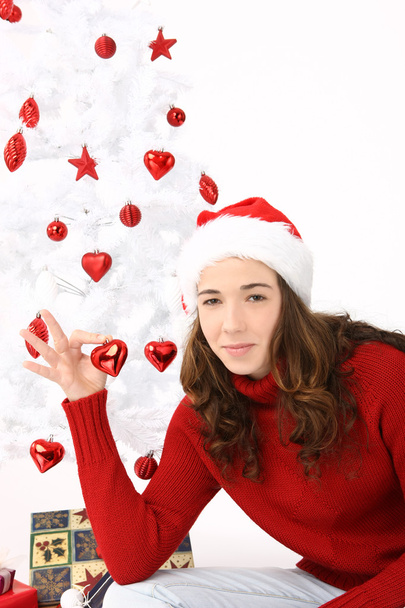 Woman wearing santa hat holding an heart - Foto, Imagen