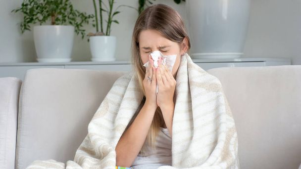 Portrait de femme malade au nez qui coule et qui se mouche dans un mouchoir en papier
 - Photo, image