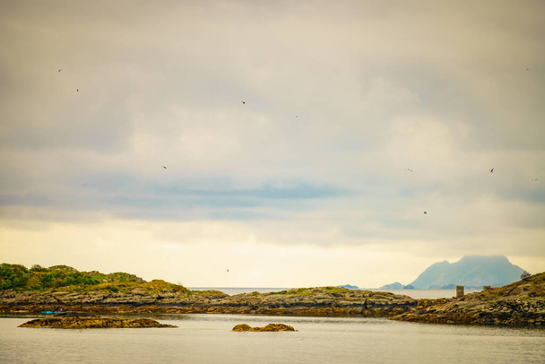 Sea landscape with stone isles on fjord Vjestfjord, Lofoten islands, Henningsvaer region, Norway. Hazy day, overcast weather. - Fotó, kép