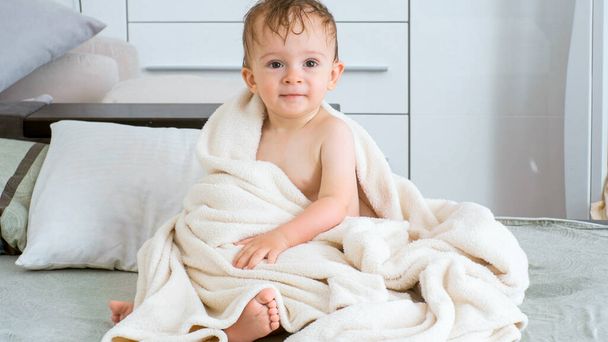 Ritratto di carino bagnato bambino dopo aver fatto la doccia seduto sul letto
 - Foto, immagini