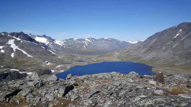 Lago em frente a montanhas com neve no Parque Nacional Jotunheimen Noruega
 - Foto, Imagem