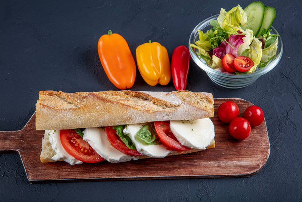 Sandwich with basil sauce, fresh lettuce, tomato and mozzarella. - Фото, зображення