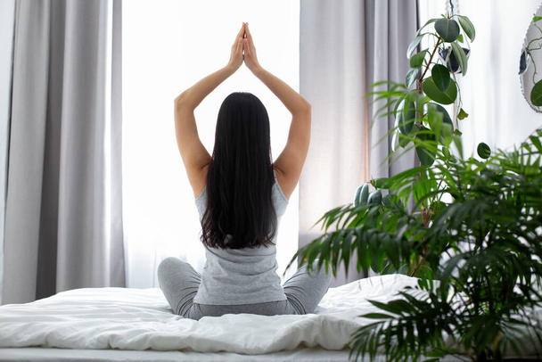 Slim woman doing yoga in bedroom in morning - Foto, afbeelding