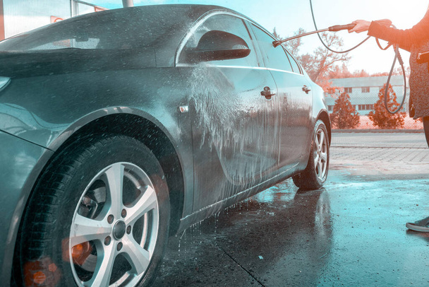 Service propre des véhicules. Laver à la main automatique du savon à eau. Laveuse de voiture en mousse sur une station plus propre. Soin à la cire sous pression
 - Photo, image