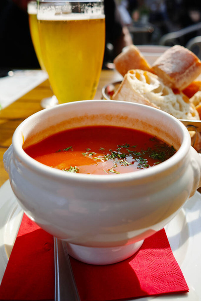 Świeże warzywa zupa kremowa serwowana w białej misce z chlebem na tarasie w świetle słonecznym - Zdjęcie, obraz