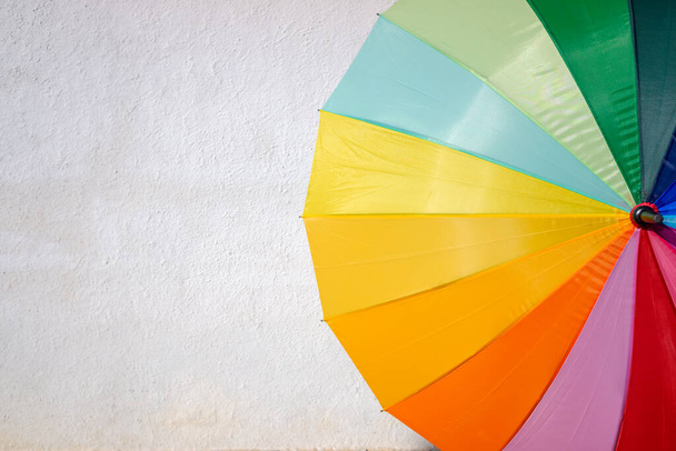 Paraguas colorido aislado en una pared de fondo blanco un día soleado. - Foto, Imagen
