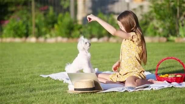 Klein lachend meisje spelen met puppy in het park - Video