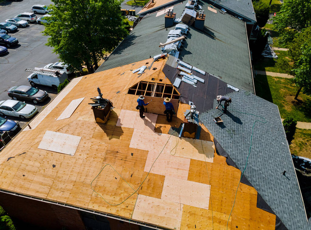Trabajador de la construcción en un techo de renovación de la casa instalado nuevas tejas - Foto, imagen
