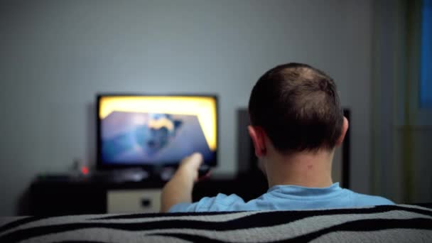 Hombre solitario pasa la noche en el televisor, vista trasera, movimiento de la cámara
 - Metraje, vídeo