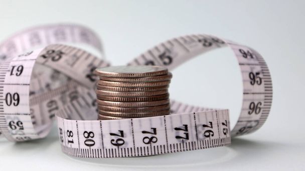 Una cinta métrica de monedas envueltas alrededor de una pila
. - Foto, imagen