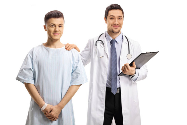 Male doctor holding a young male patient on the shoulder isolated on white background - Φωτογραφία, εικόνα