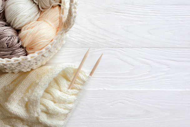 Cozy homely atmosphere. Female hobby knitting. Yarn in warm colors. Pink, peach, beige, white and green. The beginning of the process of knitting a women's sweater. - Fotó, kép