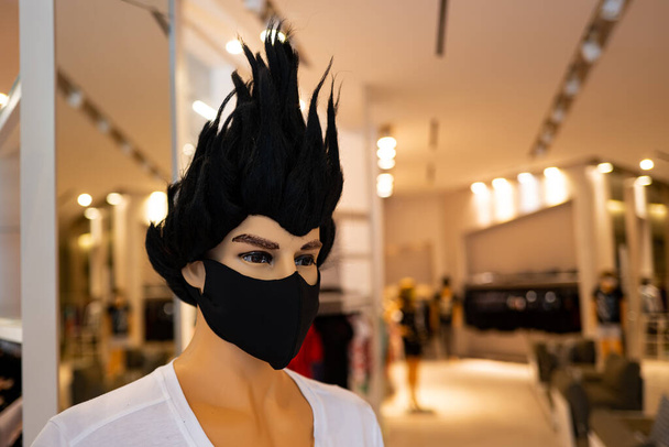 Hombre enmascarado de moda con pelo negro. Escaparatismo para tiendas de ropa durante una pandemia
. - Foto, Imagen