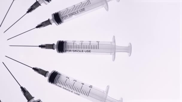 Top view. Syringes with needles rotate on a white background - Footage, Video