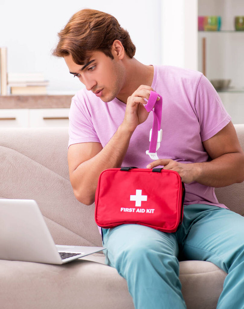 Hombre enfermo en casa con botiquín de primeros auxilios
 - Foto, Imagen