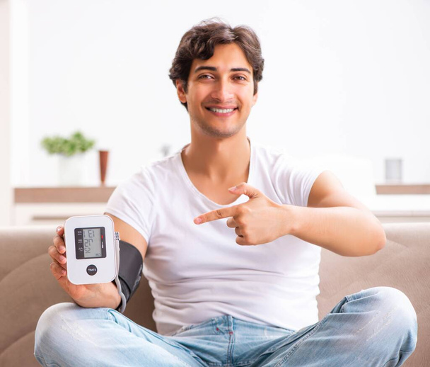 Young man measuring blood pressure at home - Photo, Image