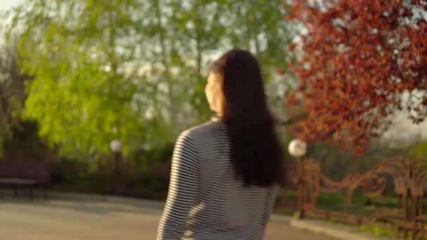 Mujer caminando en el parque de la ciudad, atardecer
 - Imágenes, Vídeo