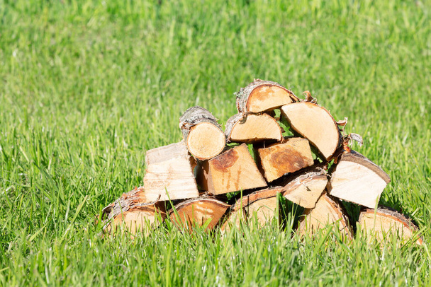 Vers berken brandhout op een achtergrond van groen gras - Foto, afbeelding