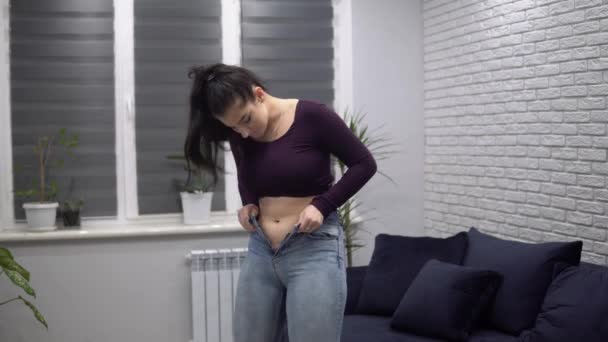 Mujer obesa con sobrepeso levantando jeans ajustados cintura gorda con jeans pequeños
 - Imágenes, Vídeo