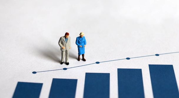 A miniature older people standing on a bar graph. - Photo, Image