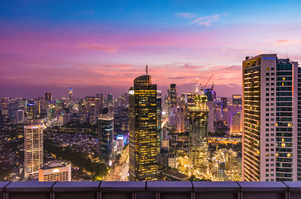 Luchtfoto van Jakarta Central Business District bij zonsondergang / schemering. Jakarta stadsgezicht bij zonsondergang. - Foto, afbeelding