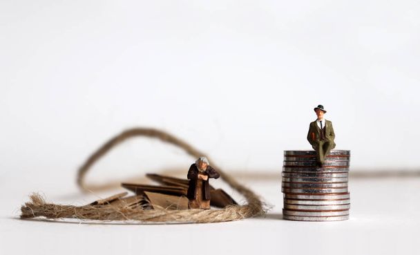 Монеты с миниатюрными людьми. Концепция разрыва поколений между богатыми и бедными
. - Фото, изображение