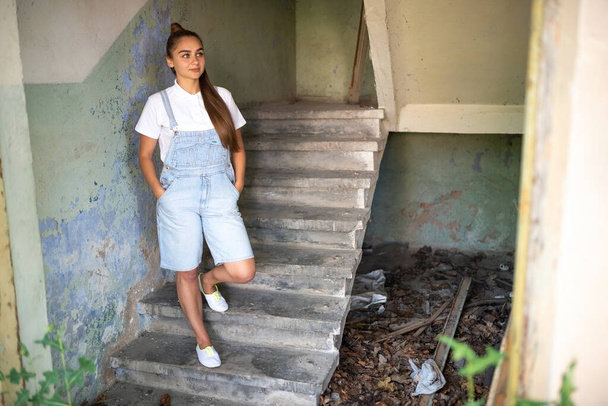Κορίτσι σε ένα εγκαταλελειμμένο σπίτι με μακριά μαλλιά. Φωτογραφία υψηλής ποιότητας - Φωτογραφία, εικόνα