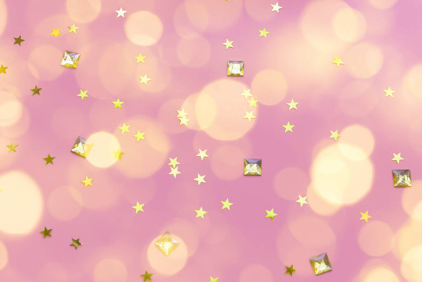 gold gems and star confetti on a pastel pink background - Fotografie, Obrázek