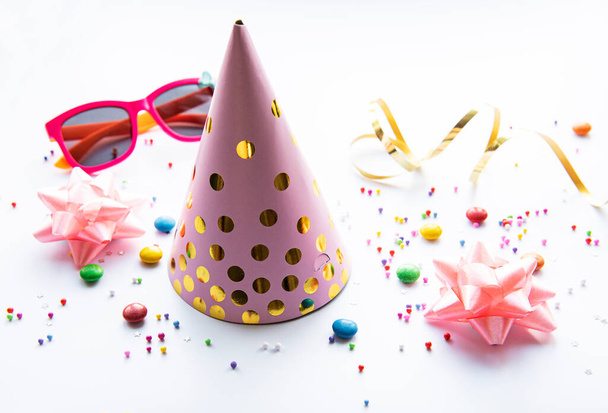 Narozeninové party čepice, dekorace a konfety na bílém pozadí - Fotografie, Obrázek
