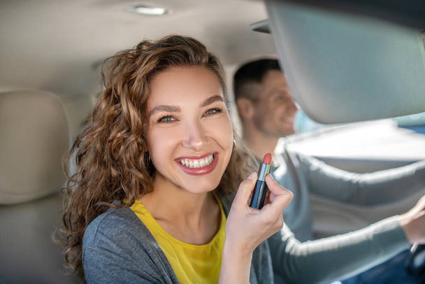 Happy smiling woman with lipstick in car - Photo, Image