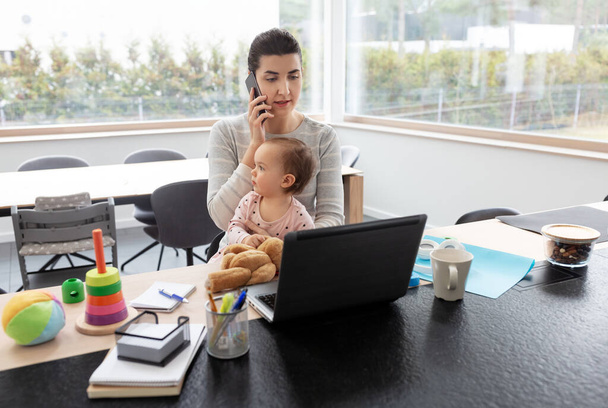 mother with baby working on laptop at home office - Φωτογραφία, εικόνα