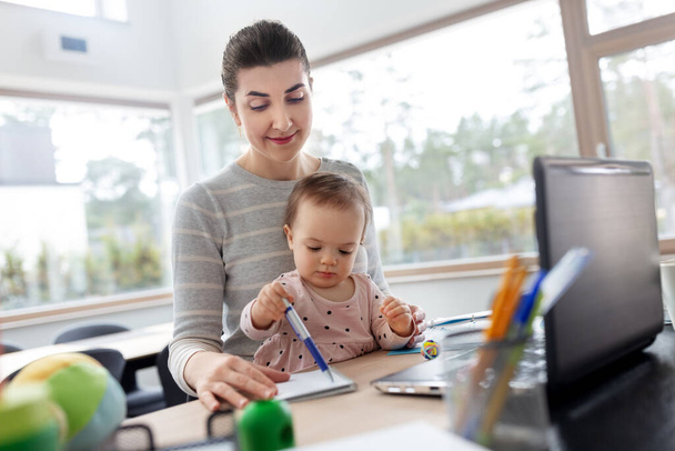 mother with baby working at home office - Foto, imagen