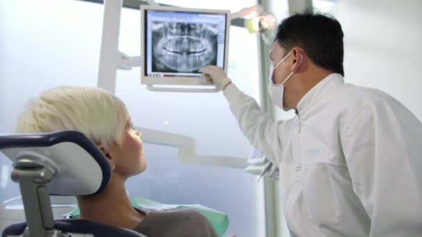Zahnarzt besucht junge Frau in Zahnarztpraxis - Filmmaterial, Video