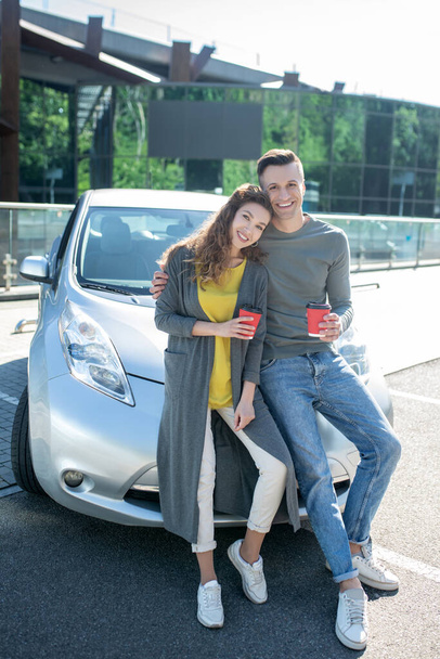 Young guy and girl standing leaning on a car - Photo, image